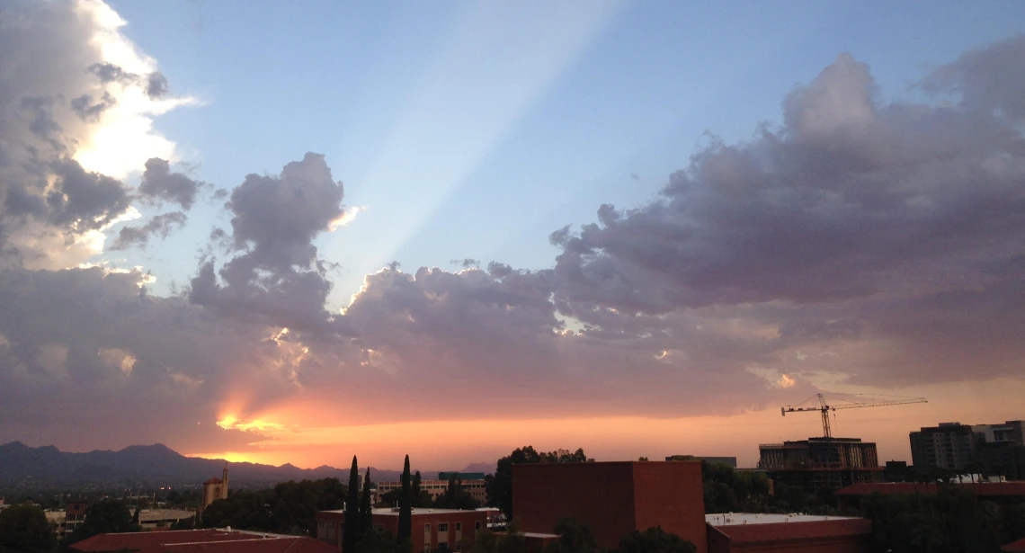 Sunset coming through clouds above UA campus